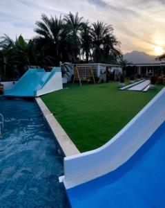 a large swimming pool with a slide and a playground at Al Sharq Holiday Home in Khor Fakkan