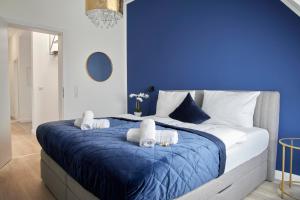 a blue bedroom with a large bed with towels on it at Schlossberg Residences - XXL-Design-Apartment mit Schlossblick für bis zu 10 Personen in Schwetzingen