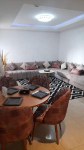 a living room with a table with chairs and a couch at Appartement meublé in Agadir