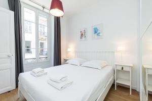 a white bedroom with a white bed and two windows at Confort Downtown 2 Bdr in Nice