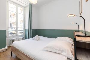 a bedroom with a white bed and a window at Confort Downtown 2 Bdr in Nice