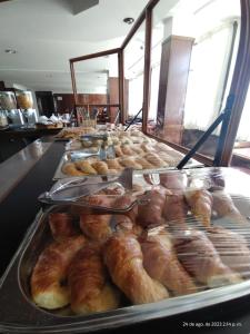 una vitrina llena de diferentes tipos de donuts en Hotel Victoria en Comodoro Rivadavia