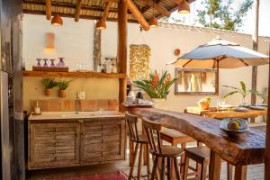 una cocina al aire libre con bar, mesa y sillas en Casa da Luz - Vila Serena, Trancoso, en Trancoso