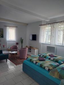 a bedroom with a bed and a living room at Penzion U Radnice in Doksy
