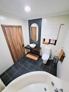 ein Badezimmer mit einer Badewanne, einem WC und einem Waschbecken in der Unterkunft Bird of Paradise in Mosta