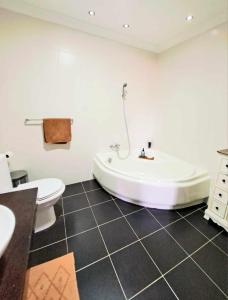 ein Bad mit einer Badewanne und einem WC in der Unterkunft Bird of Paradise in Mosta