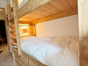 een slaapkamer met een houten stapelbed met witte lakens bij Appartement Samoëns, 3 pièces, 7 personnes - FR-1-624-19 in Samoëns