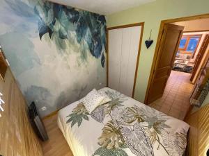 - une chambre avec un lit et une peinture murale dans l'établissement Haut Doubs Belvédère, à Les Hôpitaux-Neufs