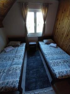 2 Betten in einem Zimmer mit Fenster in der Unterkunft House Bozovic in Žabljak