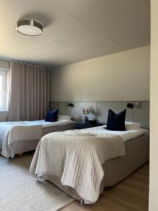 1 Schlafzimmer mit 2 Betten und blauen Kissen in der Unterkunft Höllviksnäs möten mat logi in Höllviken