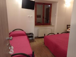 a room with two beds and a window and a tv at AFFITTACAMERE RISTORANTE GUAITA SANT'EUTIZIO in Preci