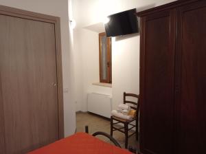 a bedroom with a bed and a chair and a television at AFFITTACAMERE RISTORANTE GUAITA SANT'EUTIZIO in Preci