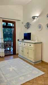 ein Wohnzimmer mit einem Schreibtisch und einem TV in der Unterkunft Villa Luca in Budoni
