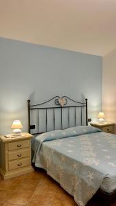 ein Schlafzimmer mit einem Bett und zwei Nachttischen in der Unterkunft Villa Luca in Budoni