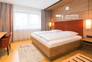 a bedroom with a large bed with a wooden headboard at Hotel SCHNEIDER in Allersberg