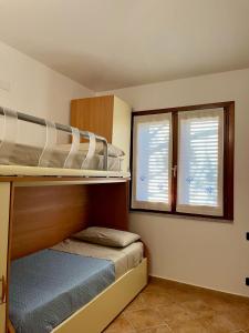 Un dormitorio con dos literas y dos ventanas. en Villa Luca, en Budoni