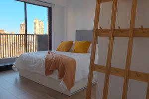 a bedroom with a bed with yellow pillows and a balcony at Studio con amenities en Palermo - Recoleta in Buenos Aires +16 photos