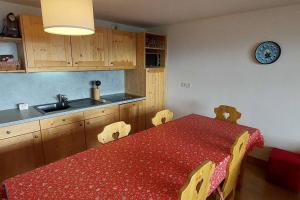 a kitchen with a red table and chairs and a sink at Paradiski bel appartement rénové plan peisey in Peisey-Nancroix