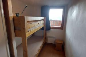 a bunk bed in a small room with a window at Paradiski bel appartement rénové plan peisey in Peisey-Nancroix