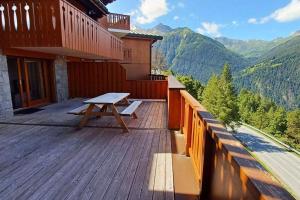 a wooden deck with a picnic table on top of a building at Paradiski bel appartement rénové plan peisey in Peisey-Nancroix