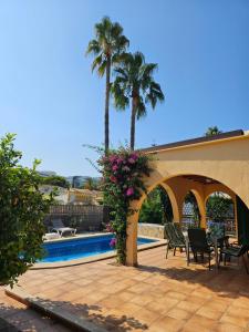 un patio con palmeras y una piscina en Casa Heli 2 en Puerto de Alcúdia