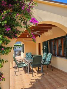 un patio con mesa, sillas y flores en Casa Heli 2 en Puerto de Alcúdia