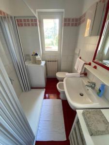La salle de bains est pourvue d'un lavabo, de toilettes et d'un miroir. dans l'établissement Dimora Sofia, à Rovetta