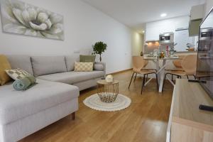 sala de estar con sofá y comedor en Canteras Suite Gran Canaria en Las Palmas de Gran Canaria