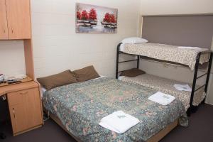 a room with two bunk beds and a desk at The Swiss Motel in Cooma