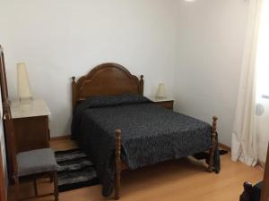 a bedroom with a bed and a table and a chair at Casa do Carroça in Terreiros