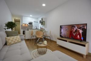sala de estar con TV de pantalla plana grande en Canteras Suite Gran Canaria en Las Palmas de Gran Canaria