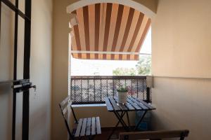 una mesa con una maceta en la parte superior de un balcón en Apartamento America, en Sanlúcar de Barrameda