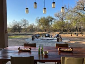 a wooden table with chairs and a large patio at Mananga Bush Villa in Skukuza