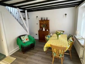 a dining room with a table and a green chair at Beautiful Mumbles/Gower cottage in Swansea