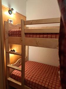 quelques lits superposés dans une chambre dans l'établissement Appartement Montagnard Serre-Chevalier., à Saint-Chaffrey