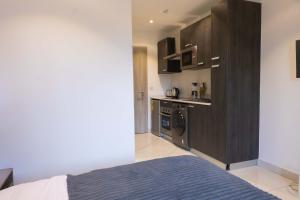 a bedroom with a bed and a kitchen in it at The Eden Suite in Accra