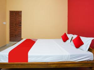a bedroom with a large bed with red and white pillows at Hotel O Lakshmi Sri Boarding & Lodging in Bengaluru