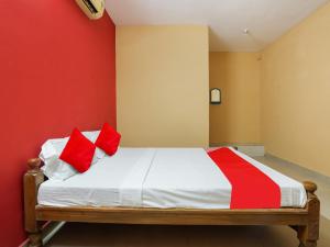 a bedroom with a bed with red and yellow walls at Hotel O Lakshmi Sri Boarding & Lodging in Bengaluru