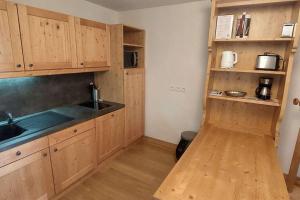 a kitchen with wooden cabinets and a sink at Paradiski bel appartement rénové plan peisey in Peisey-Nancroix