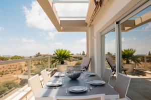 a dining table and chairs on the balcony of a house at Modern holiday apartment with incredible sea views in La Cala de Mijas in Málaga