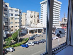 een raam met uitzicht op een parkeerplaats met auto's bij Bacău Central in Bacău