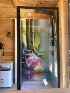 a glass window with a pink flower in a vase at Gite et Studio "A l'accueil des Papillons" in Courrières