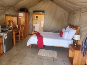 1 dormitorio con 1 cama en una tienda de campaña en Eagle Ranch Lodge en Mafikeng