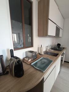 a kitchen with a counter with a sink and a microwave at emplacement idéal, vue mer, parking offert in Sanary-sur-Mer