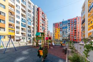 a playground in a city with tall buildings at ЖК Теремки in Almaty