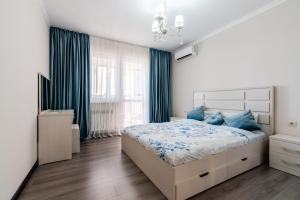 um quarto com uma cama grande e almofadas azuis em ЖК Теремки em Almaty