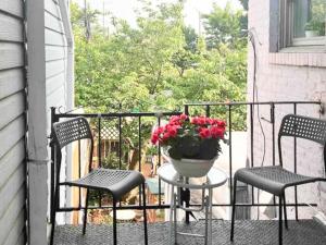 un balcón con 2 sillas y un jarrón de flores en Charming 2nd Fl Retreat, Heart of Capitol Hill, en Washington