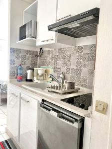 a white kitchen with a sink and a stove at Apt T1,bien situé Anse Mitan Trois Ilets in Les Trois-Îlets