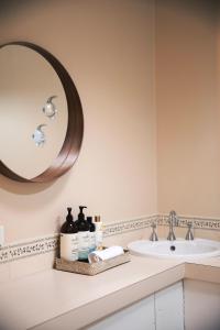y baño con lavabo y espejo. en Incredible Waterview - 4 Bedroom Hobart Waterside Cottage, en Sandy Bay