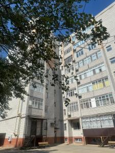 un gran edificio con una escalera delante en Уютная и комфортная 3х комнатная в новом центре, en Uralsk